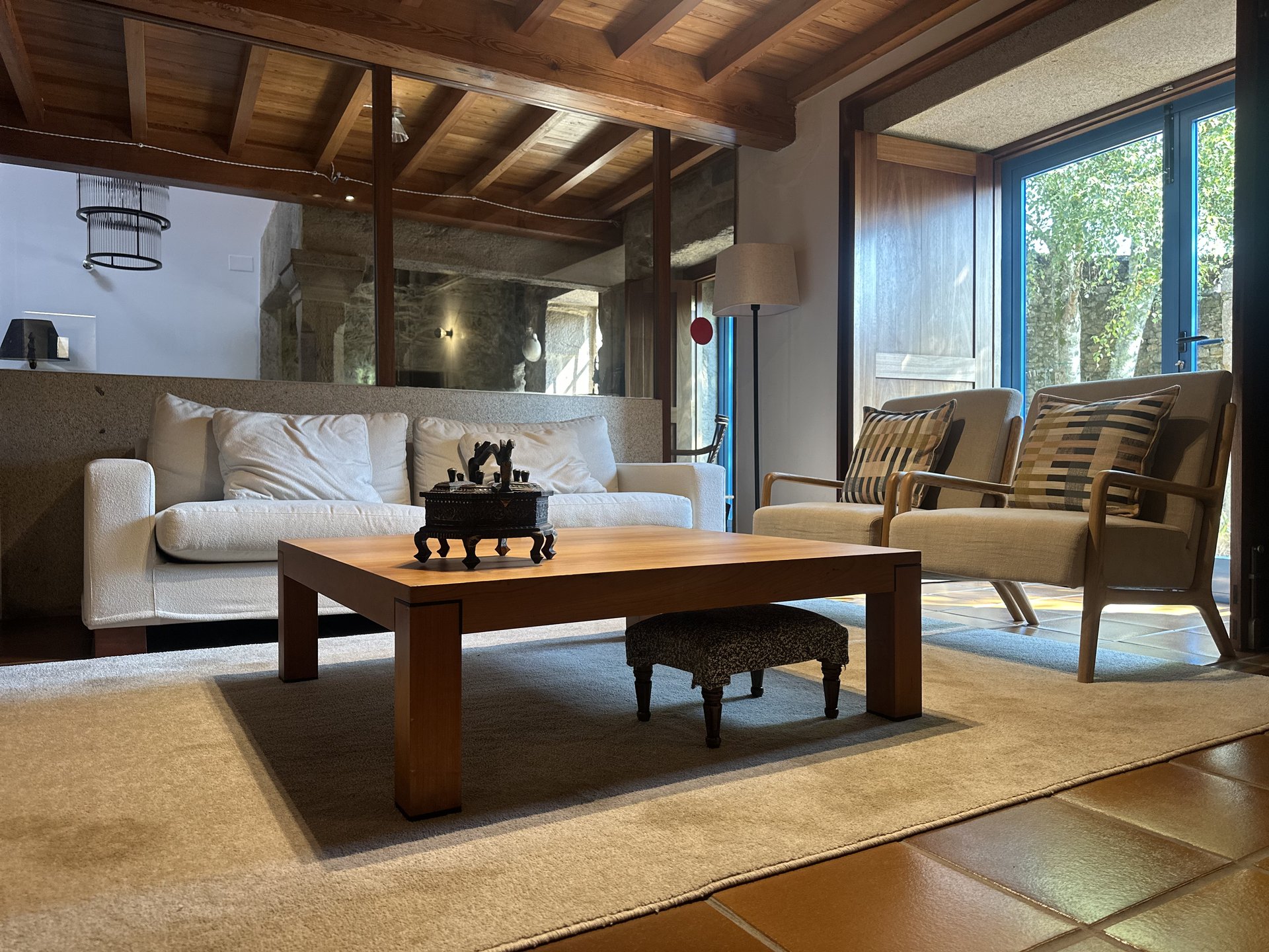 Salón planta baja con sofás y vistas al jardín — casa rural gallega cerca de Santiago